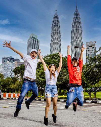 Friends jumping high, background Twin Tower