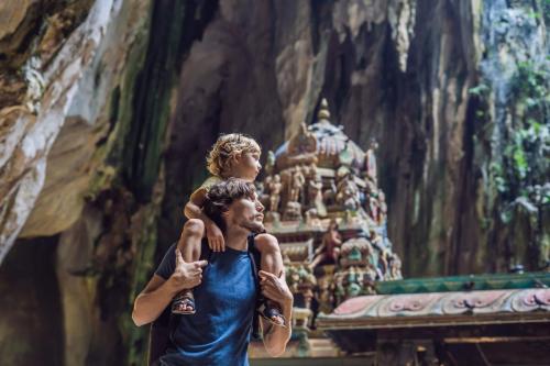 Father,And,Son,In,The,Background,Of,Batu,Caves
