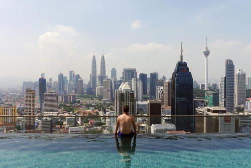 man on swimming pool , with twin tower view
